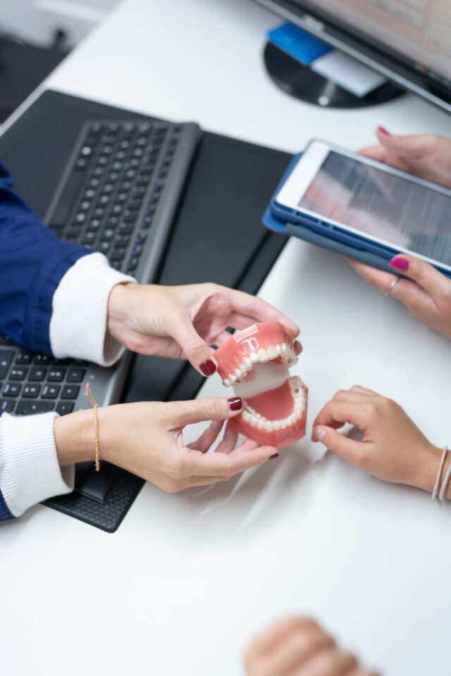 Profesional explicando tratamiento con modelo dental